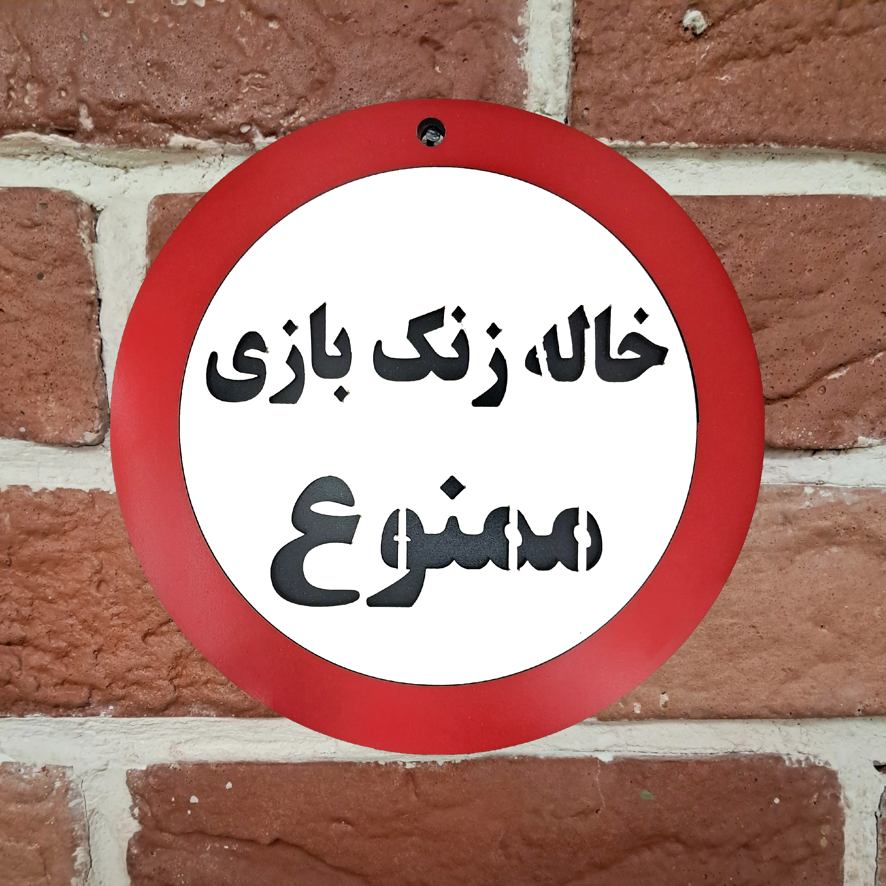 تابلو اخطاری خاله زنک بازی ممنوع نصب شده روی دیوار آجری