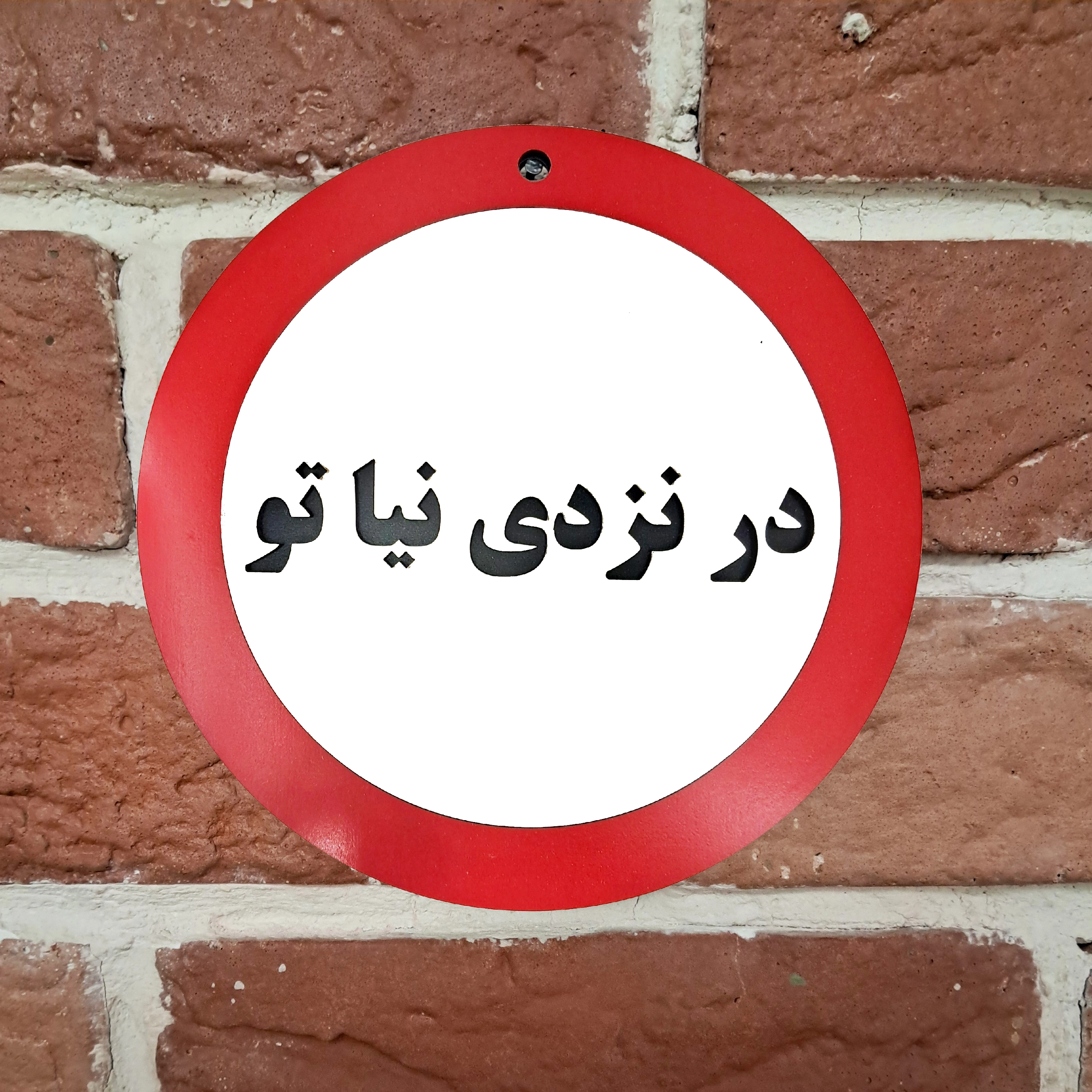 تابلو اخطاری در نزدی نیا تو نصب شده روی دیوار - ترکیبی از رنگ های مشکی، سفید و قرمز