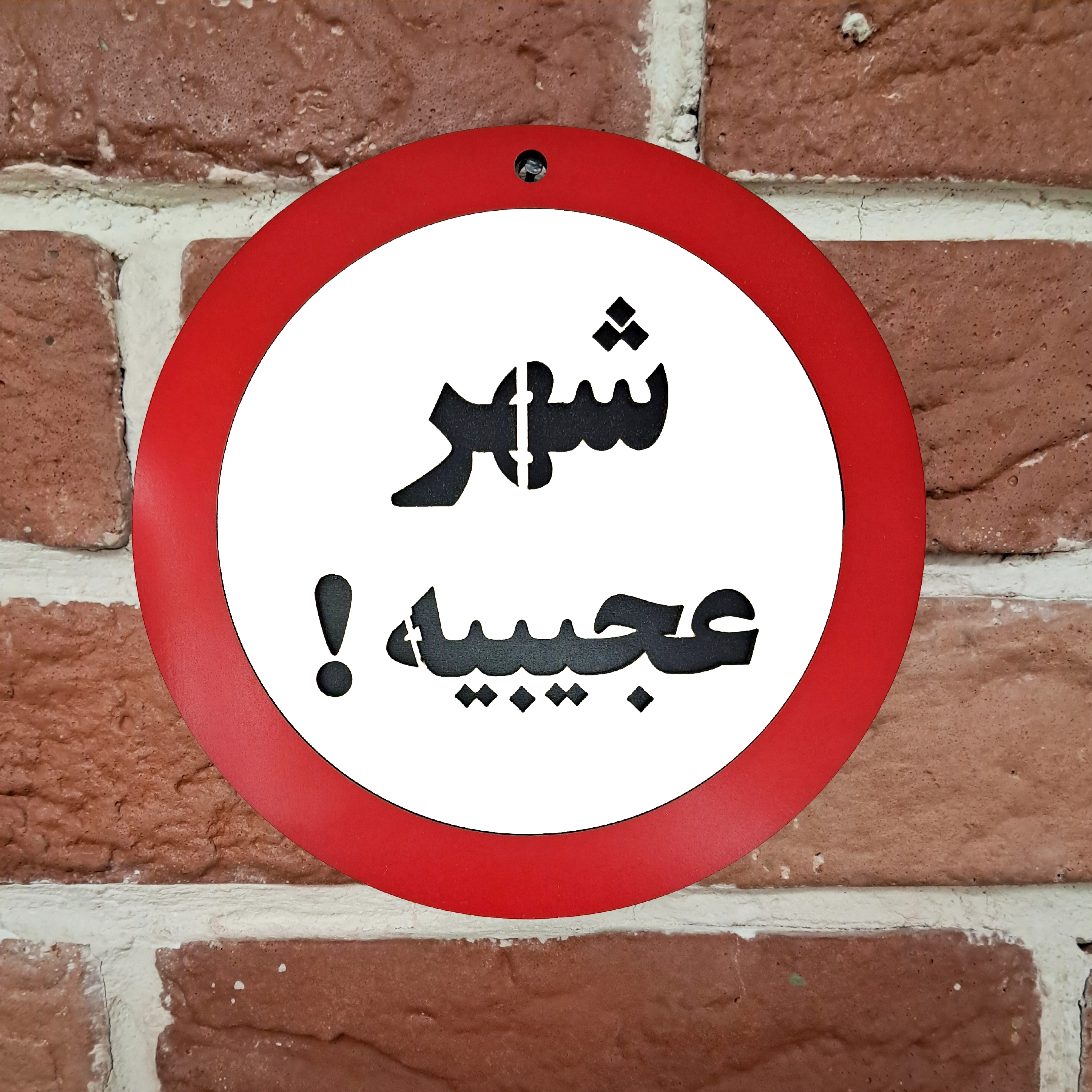 تابلو اخطاری شهر عجیبیه نصب شده روی دیوار