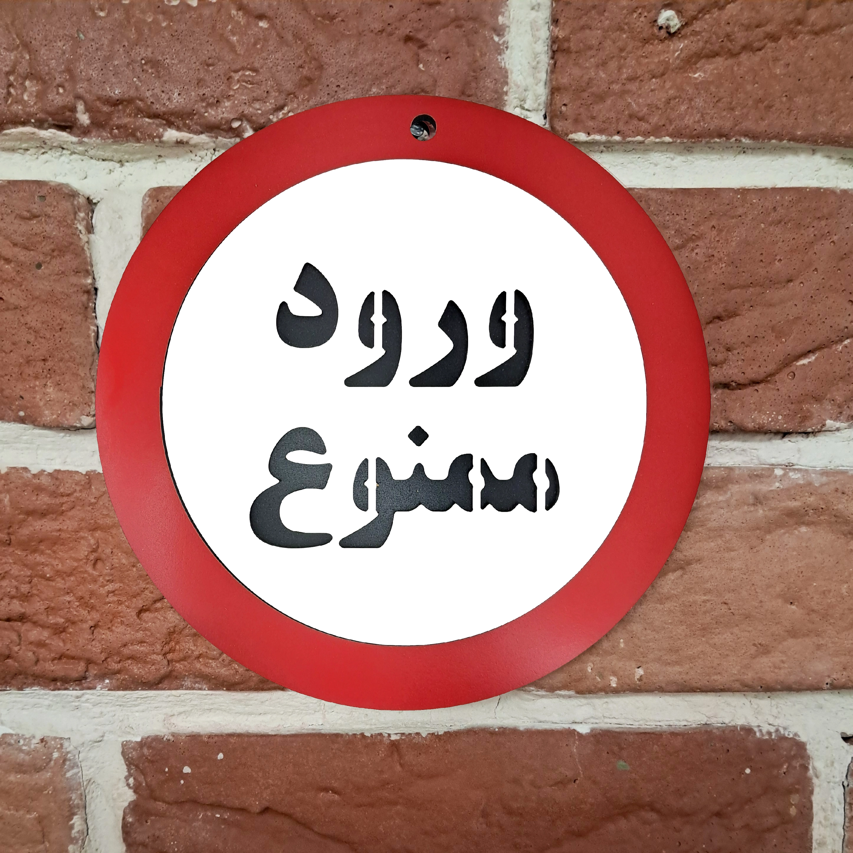 تابلو دیواری ورود ممنوع نصب شده روی دیوار آجری