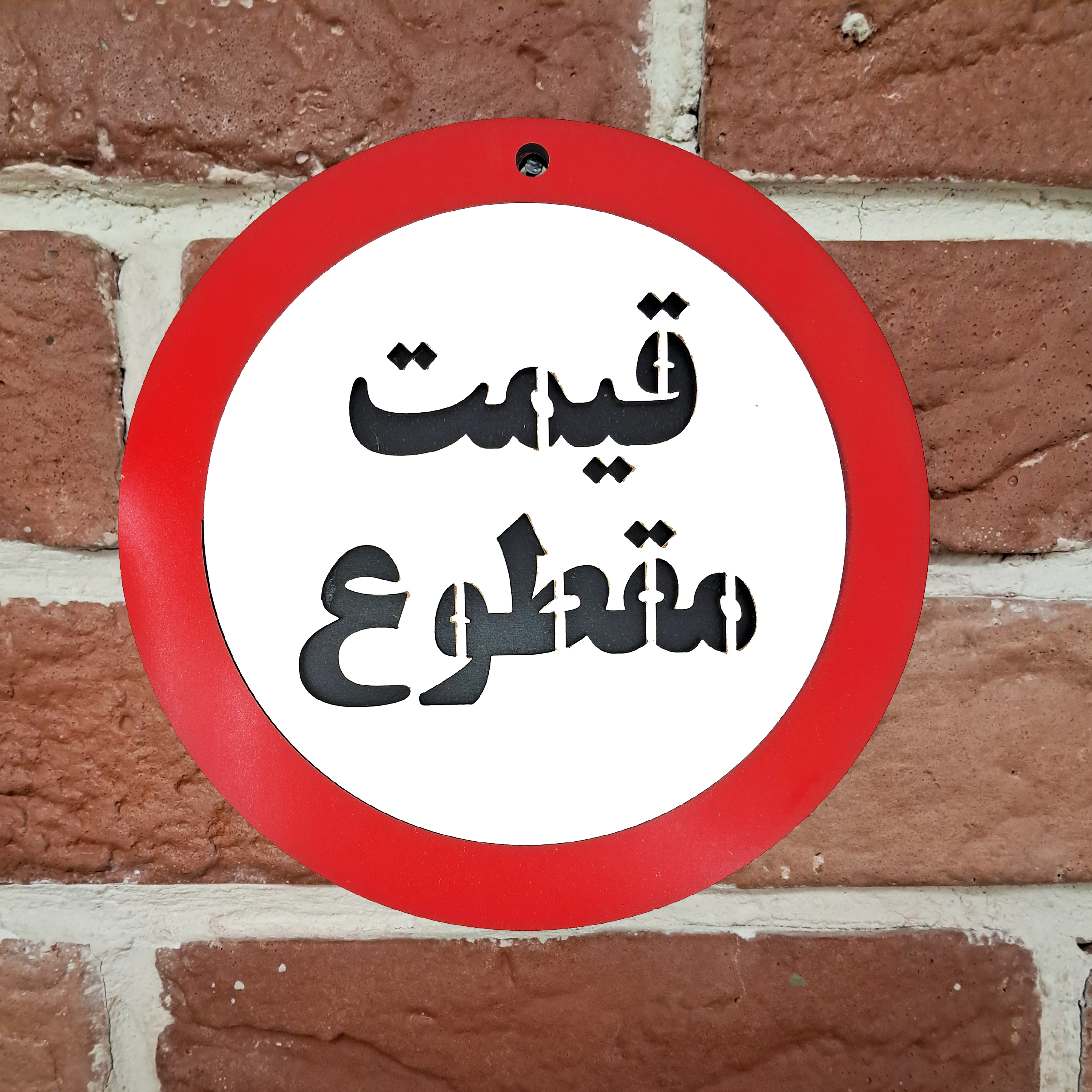 تابلو علامت قیمت مقطوع نصب شده روی دیوار آجری با میخ