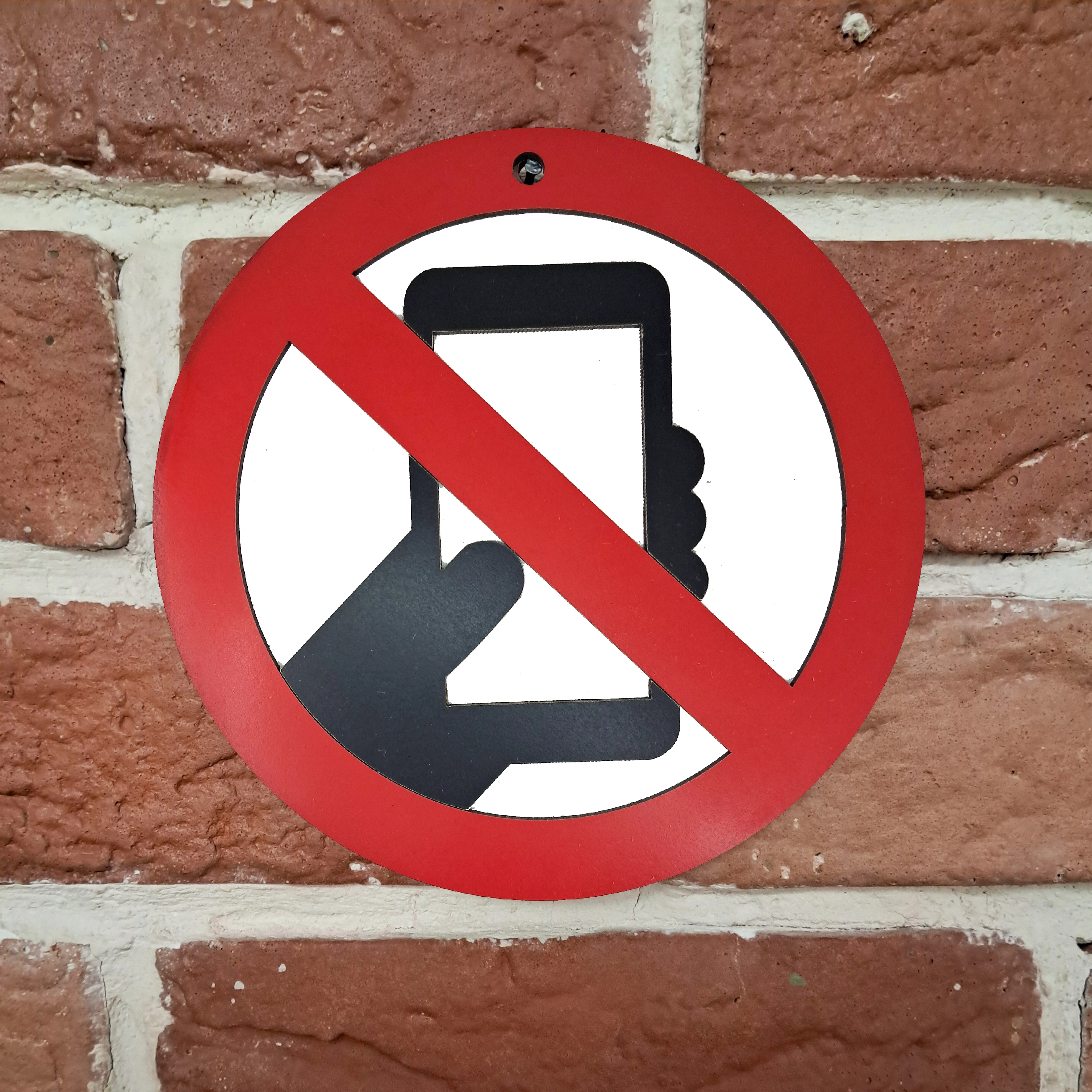 تابلو اخطاری گوشی ممنوع نصب شده روی دیوار